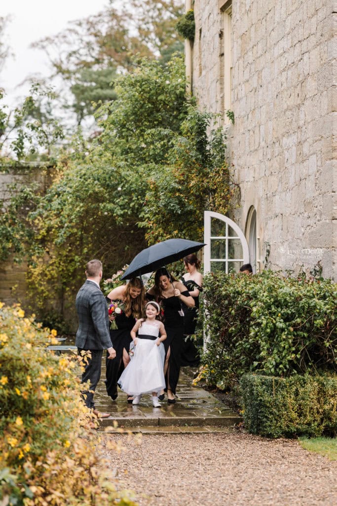 Bridal party arriving at a rainy wedding in Northumberland