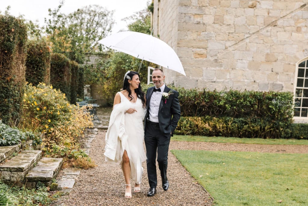 Rainy wedding day photograph of bride and groom at their wedding venue