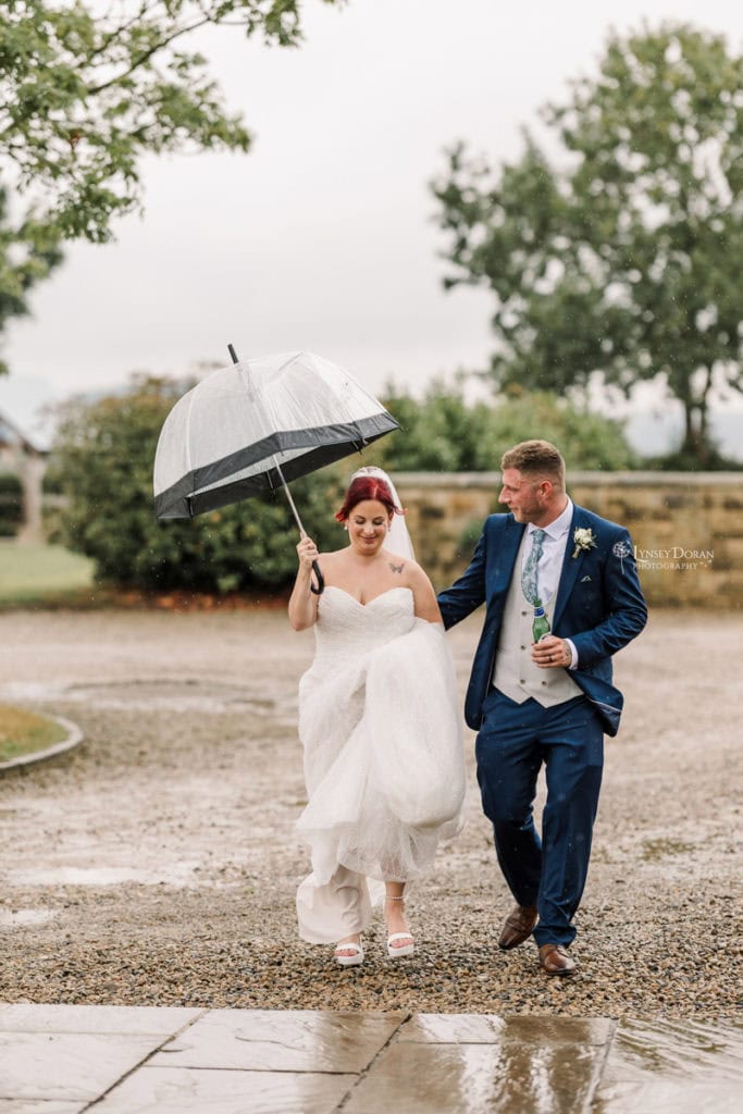 Rainy wedding day photograph of bride and groom at their wedding venue