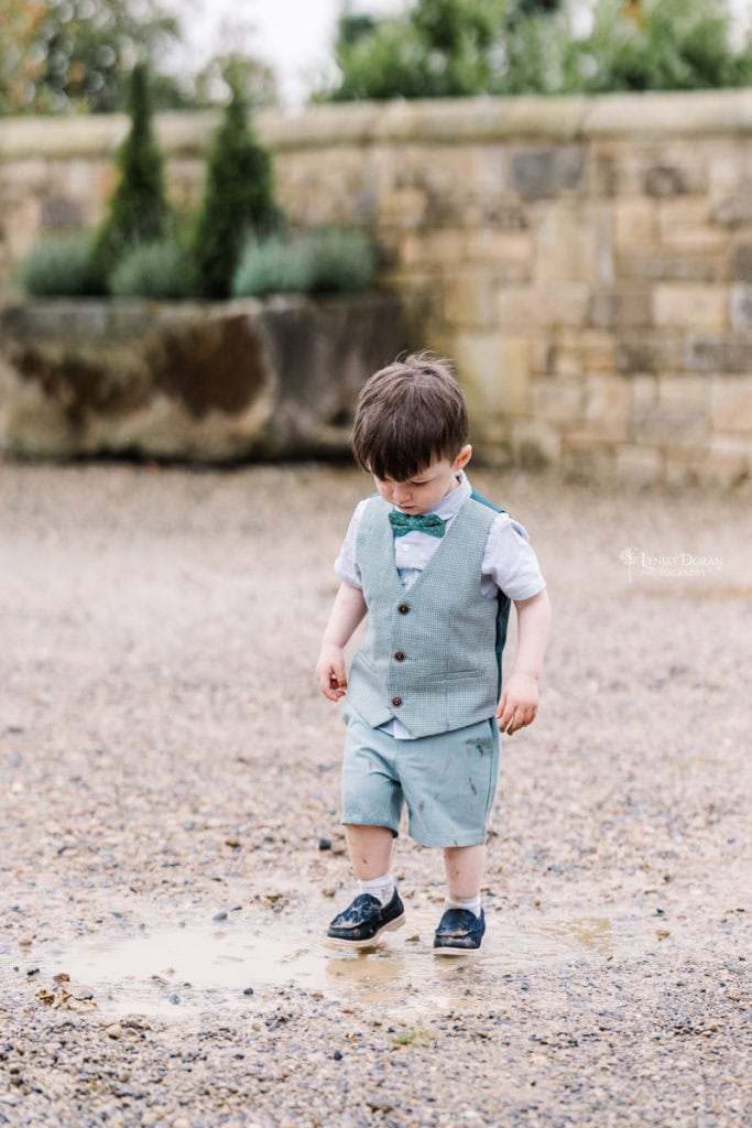 pageboy dancing in puddles on a rainy wedding day